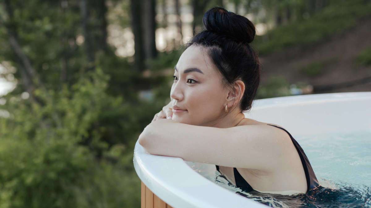 Asiatisch aussehende Frau in einem Pool im Wald.